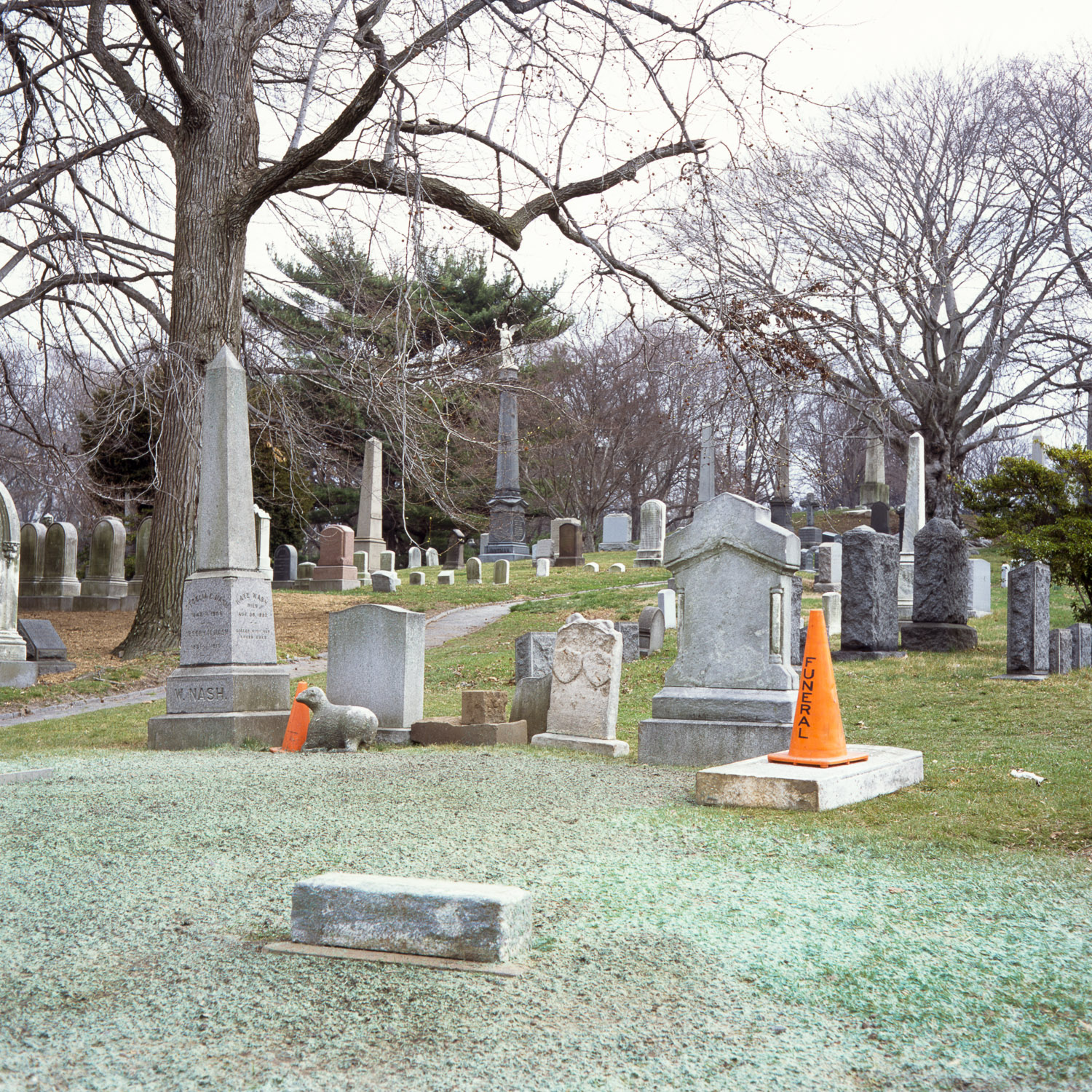 Color image of a freshly finished grave with an orange pylon labeled 'Funeral' on top of it.