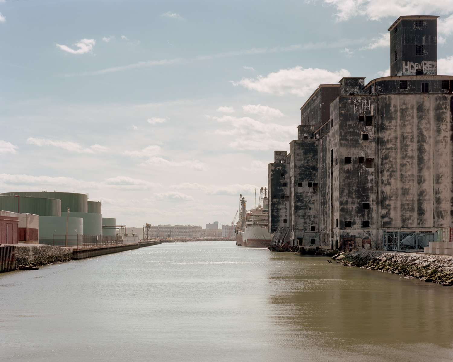 Color image of a grain terminal and oil storage tanks separated by a channel of water.