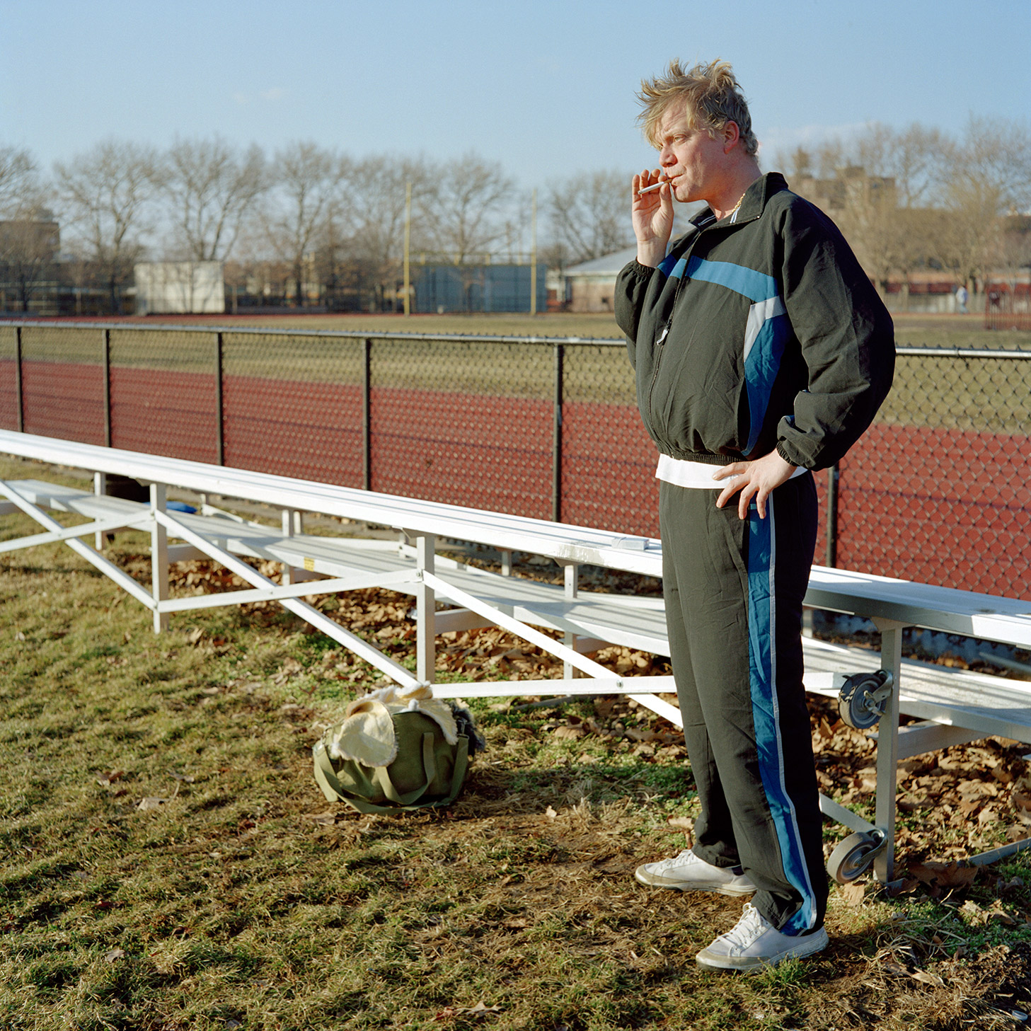 Color image of Siva avatar smoking a cigarette while standing by a bleacher.